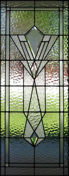 a stained glass window with an abstract design on the bottom and side panel, in green tones