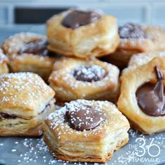 chocolate filled pastries on a plate with sprinkles and powdered sugar