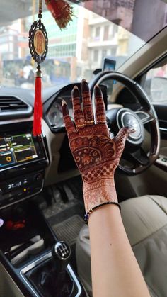 a woman's hand with hendix on it sitting in the driver's seat of a car