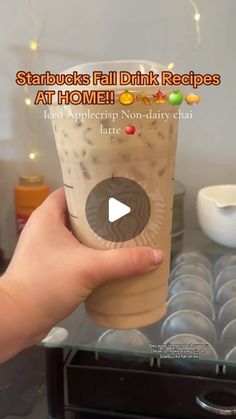 a person holding up a drink in front of a glass case with the caption starbucks fall drink recipes at home