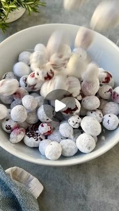 a bowl filled with white and red speckled eggs