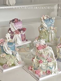 there are many different cakes on the table together, each decorated with pink and blue flowers