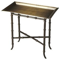 a metal tray sitting on top of a table with two legs and an iron frame