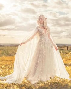 a woman in a wedding dress standing in a field