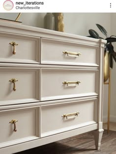 a white dresser with gold handles and knobs