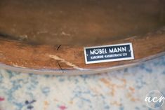 there is a label that says model mann on the back of a wooden chair with floral fabric