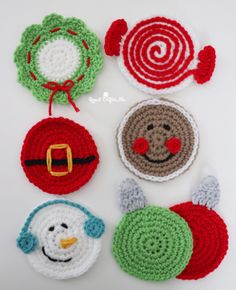 crocheted christmas ornaments are displayed on a white surface with a person's hand