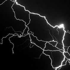 a black and white photo of lightning in the night sky