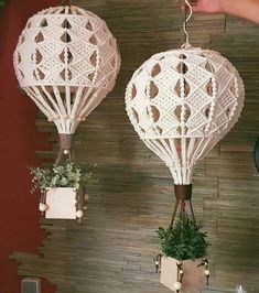 two air balloons are hanging from the wall next to some potted plants and other decorations