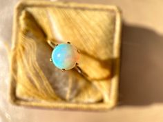 This vintage gold exudes has an inviting warm contrast to the blues and oranges bursting from this opal! We love the high prong setting that shows off this charming gem! This ring was artfully crafted from a vintage stick pin with all original pieces.   Era: Vintage Metal: 14k Yellow Gold Gem(s): Opal, 5.7mm Weight: .9 grams Current Size: 5.25 (This ring can be sized!) Classic Cabochon Opal Ring, Classic Ethiopian Opal Ring As Gift, Vintage Opal Ring As A Gift, Classic Round Cut Opal Ring, Simple Opal Ring, Opal Ring Simple, Junk Drawer, Stick Pins, The Blues