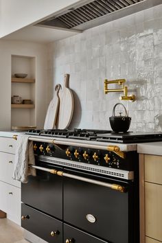 a kitchen with an oven, stove and counter top in the background is a white tiled wall