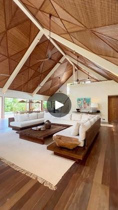 a large living room with wood floors and white furniture on the floor is shown in this image