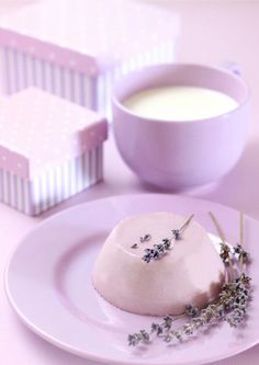 a small dessert on a plate next to a cup of coffee and some other items