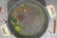 a pot filled with green vegetables and spices