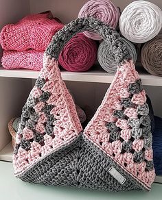 a crocheted purse sitting on top of a white shelf next to yarns