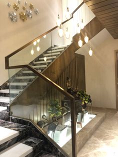 a staircase with glass railing and lights hanging from the ceiling