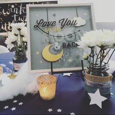 there are flowers in vases on the table next to a sign that says love you to the moon and back