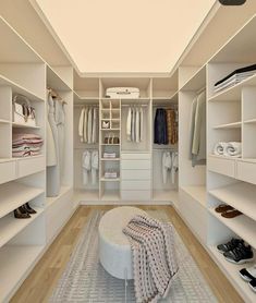 a walk in closet filled with lots of white shelves