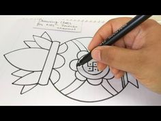 a person is drawing on paper with a marker and pen in front of the coloring page