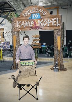 a man standing behind a chair holding a sign