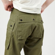 Cut from a crisp herringbone twill, 100% cotton fabric, the M-1944 trouser is a versatile design from American military history. Loved by heritage enthusiasts the world over for its superb versatility, and functionality, this trouser offers a wide leg, and a high rise for superb freedom of movement. Two large pockets on the thighs, and one large pocket on the seat are secured by custom manufactured donut buttons, which have been stamped with the U.S. Marine Corps moniker. A wind flap button fly Wicked Fashion, Herringbone Pants, American Military History, Casual Work Pants, Capsule Wardrobe Pieces, Flat Felled Seam, American Military, Stylish Men Casual, Army Fashion