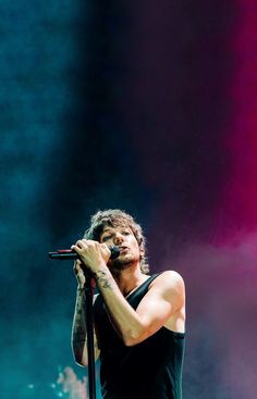 a man holding a microphone on top of a stage