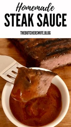 homemade steak sauce in a white bowl on a wooden table with a fork and knife