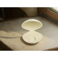 a white vase sitting on top of a window sill