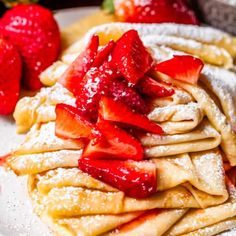 pancakes with powdered sugar and strawberries on top