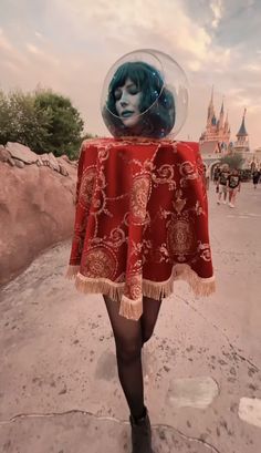 a woman with blue hair wearing a red cape