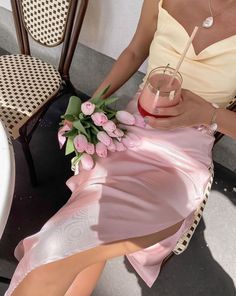 a woman in a pink dress holding a drink