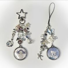 two earrings with charms attached to them on a white surface, one has an angel and the other has a star