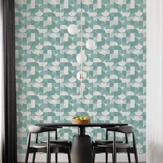 a dining room table with four chairs in front of a wallpapered background that has geometric shapes on it