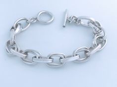 "Retro Modern Inspired Sterling Silver Thick Oval Link Single And Double Cross Over Cable Link Toggle Bracelet. Clean bold contemporary look. Lightly polished ready to wear.   Stamped Maker Mark: 925 stamped Italy Size: Length is 7 1/2\" long laying flat, 6 1/2\" inside circumference closed,  links are 5/8\" x 3/8\" each.    Weight: 31.54 grams Condition: Good Vintage Condition ready to wear condition reflecting minimal wear.   Please review the photos for visual detail and let me know if you have any further questions prior to purchase. I don't offer returns or exchanges. See my other listings for more Vintage and Modern Jewelry. Sales are final. USA sales only." Elegant Sterling Silver Bracelet With Oval Link Toggle Clasp, Modern Link Sterling Silver Bracelet With Toggle Clasp, Modern Sterling Silver Bracelet With Toggle Clasp, Modern Oval Link Bracelet With Toggle Clasp, Stamp Maker, Silver Chain Style, Toggle Bracelet, Retro Modern, Chain Link Bracelet