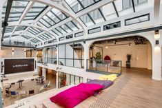 the interior of an office building with large windows and colorful pillows on the floor in front of it