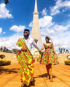 two people dressed in brightly colored clothing standing next to each other