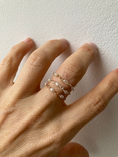 This little chain ring offers a fresh take on a traditional band ring. It is also very lightweight and comfortable to wear.  D E T A I L S *Made with AAA grade cultured freshwater rice pearls. These are very small measuring between 2- 4mm x 1.5mm. *Choose between a 14k gold filled, rose gold filled or sterling silver chain. *Gold fill is a wonderful alternative to gold and unlike gold plating does not rub off. *Choose the size you prefer from the drop down menu.  *Ring comes with a matching crystal information card and is ready for gifting. S I Z I N G * H E L P:  The the most accurate way to determine your ring size is to be professionally measured by a jeweller.  There are also several at-home sizing tools and tips to help find your ring size. The MOST COMMON RING SIZES for women are siz Delicate 14k Gold Filled Midi Rings In Rose Gold, Delicate 14k Rose Gold Filled Midi Rings, Stackable Rose Gold Pearl Ring For Promise, Adjustable Rose Gold Open Pearl Ring, Rose Gold Stackable Pearl Promise Ring, Elegant Everyday Wire Wrapped Rings, Dainty Stackable Pearl Jewelry, Adjustable Dainty Rose Gold Pearl Ring, Adjustable Rose Gold Dainty Pearl Ring