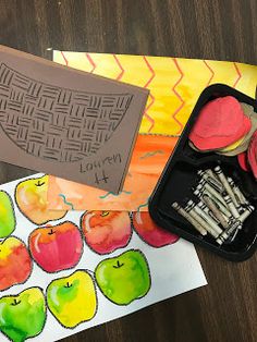 an apple themed art project with watercolors and crayons on the table