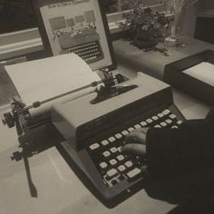 a person typing on an old fashioned typewriter