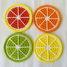 four crocheted fruit coasters sitting on top of a table