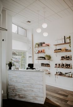 the inside of a store with shelves filled with bottles and plants on it's walls