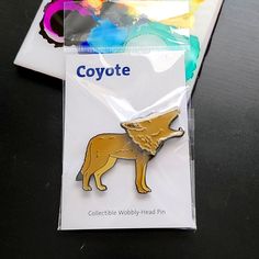 a badge with a dog on it sitting next to a package of stickers that says coyote