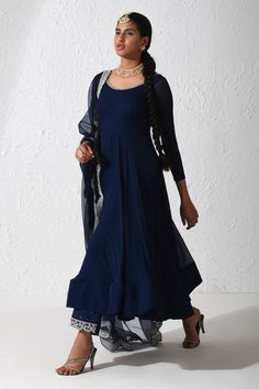 Midnight blue anarkali with zardozi embroidery on the neckline and tie up at the back. Comes with wide leg pant and scallop border embroidered dupatta.
Components: 3
Pattern: Embroidered
Type Of Work: Zardozi
Neckline: Scoop
Sleeve Type: Three Quarter
Fabric: Crepe, Organza and Raw Silk
Color: Blue
Other Details: 
Pant with zardozi embroidered hem
Dupatta with embroidered scallop border
Low back with tie up and tassels
Occasion: Wedding - Aza Fashions Blue Churidar With Gota Work For Party, Blue Anarkali Set With Mirror Work In Georgette, Blue Anarkali Salwar Kameez In Georgette, Blue Anarkali Churidar In Georgette, Blue Anarkali Kurta In Georgette, Anarkali Style Blue Georgette Churidar, Blue Anarkali Set For Transitional Season, Festive Indigo Anarkali Dress, Blue Anarkali Palazzo Set In Georgette