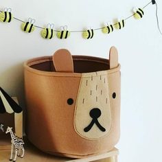 a toy giraffe is sitting next to a potted plant with bees on it