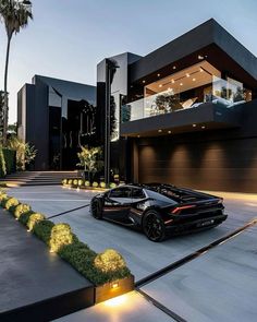 a black sports car parked in front of a modern house at night with its lights on