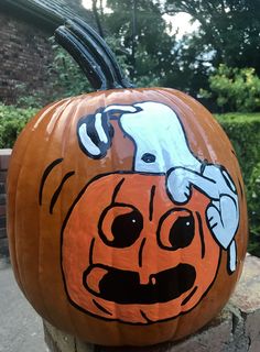 a carved pumpkin with a dog on it's face and hands sticking out from its mouth