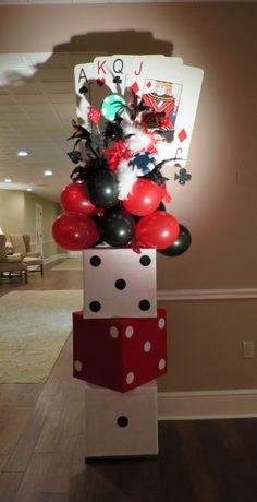 a tower with balloons and cards on it in the middle of a living room area