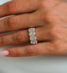 a woman's hand wearing a three stone diamond ring