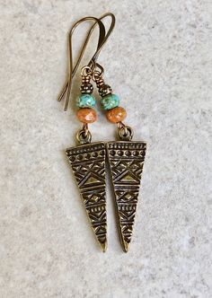 "antiqued brass triangle earrings boho earrings dangle bohemian earrings Embossed antiqued brass triangle pendants dangle below small Czech glass beads - one turquoise and one burnt orange - both with a light picasso coating. A tiny antiqued brass bead sits on top. Hook ear wires are antiqued brass. Length of earrings from top of ear wires is 2 1/4\". Triangle measures 29mm long, 1 1/8\". You can enter my shop here: gypsydangles.etsy.com" Bohemian Earrings With Antique Finish For Jewelry Making, Bohemian Jewelry With Antique Finish, Bohemian Drop Earrings With Antique Finish, Bohemian Antique Gold Drop Earrings, Bohemian Bronze Jewelry With Dangling Beads, Bohemian Copper Jewelry With Antique Finish, Bohemian Antique Finish Drop Earrings, Bohemian Bronze Earrings With Dangling Beads, Bohemian Triangle Earrings With Ear Wire