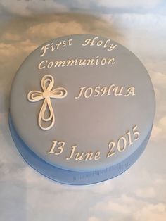 a cake with a cross on it sitting on top of a white tablecloth covered table